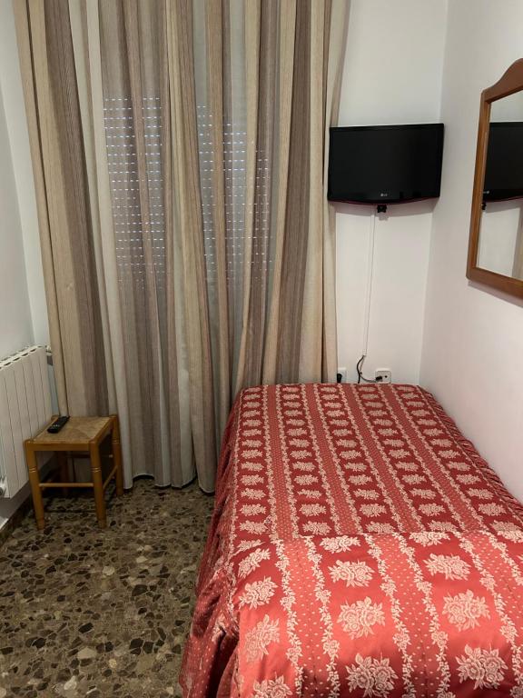 1 dormitorio con 1 cama con edredón rojo en LABELLA Hostal Restaurante, en La Calahorra
