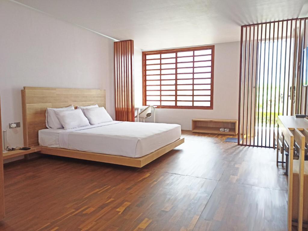a bedroom with a bed and a large window at Malino Highlands in Malino