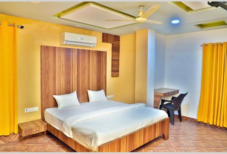 a bedroom with a large bed and a table and a chair at Tak International Hotel in Udaipur
