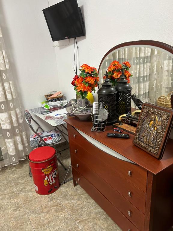 a wooden dresser with flowers on top of it at Viki’s Appartement near ktel Serron in Serres