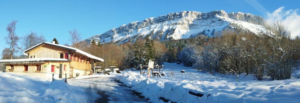 uma montanha coberta de neve em frente a um edifício em Le Cocon de Plainpalais em Les Déserts