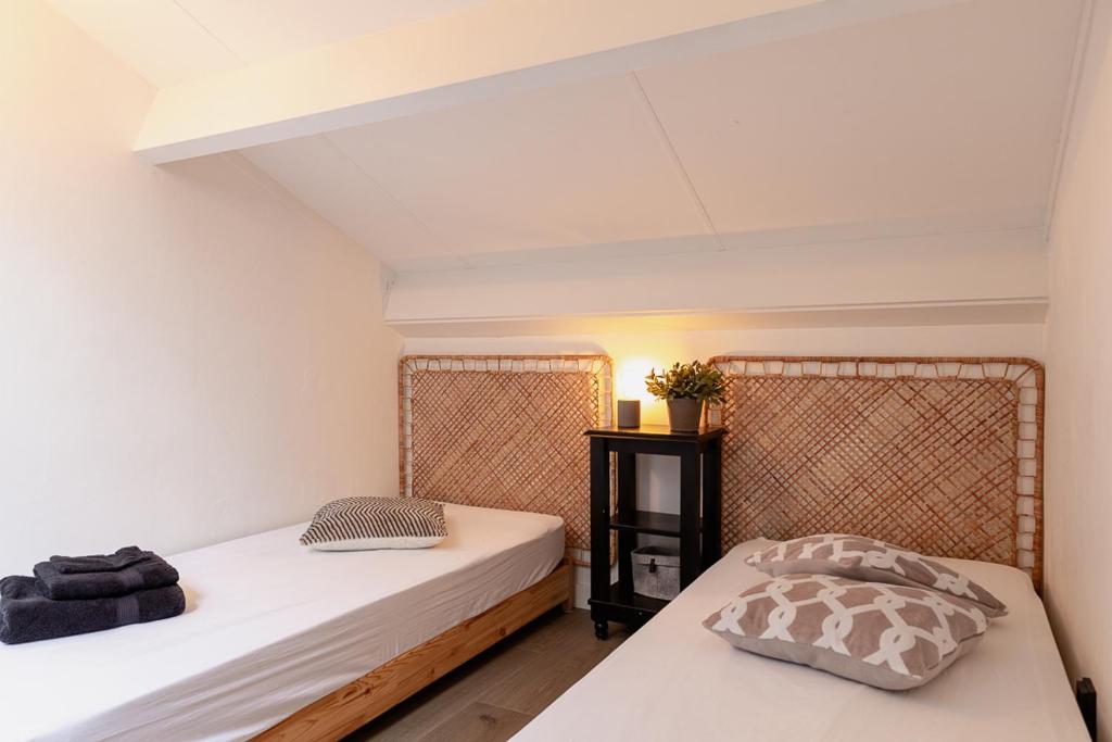 a room with two beds and a night stand at Huusje21 in Nunspeet