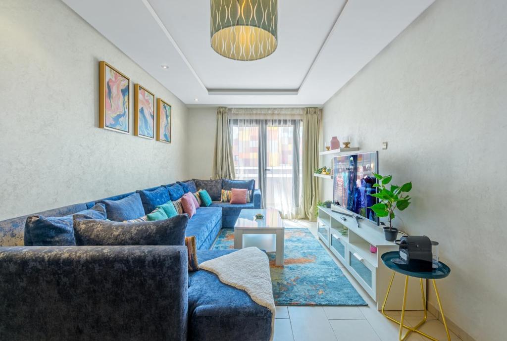 sala de estar con sofá azul y TV en Urban Charm Delight, en Casablanca