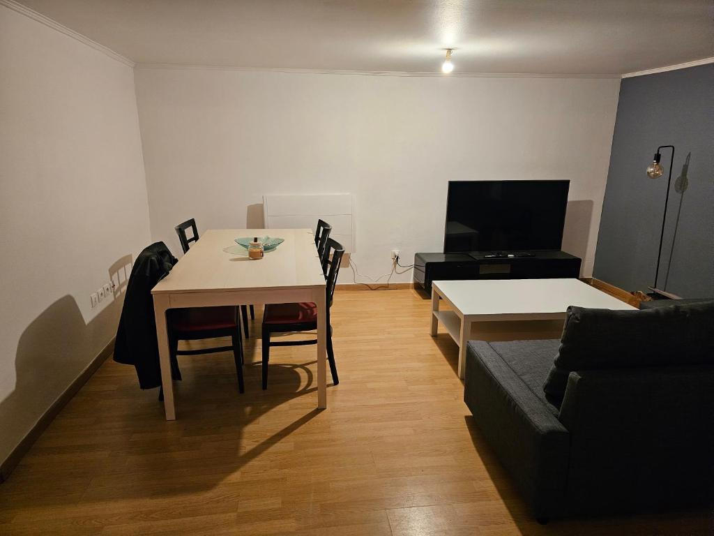 ein Wohnzimmer mit einem Tisch und einem Sofa in der Unterkunft La petite maison in Schiltigheim