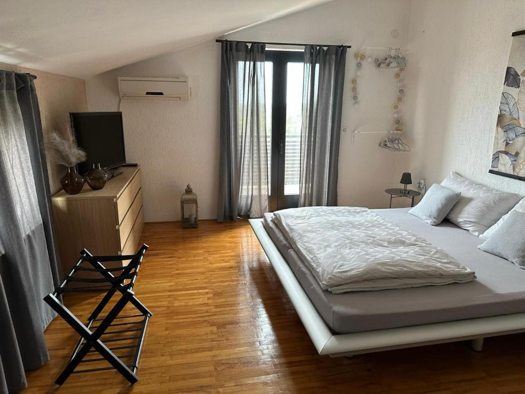 a bedroom with a large bed and a television at Ferienhaus Marija mit Pool in Vilanija