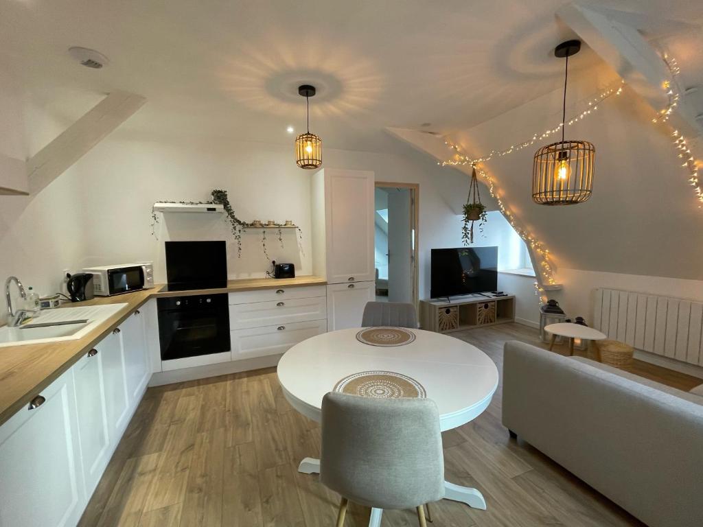 a kitchen and living room with a table and a counter at Appartement en centre ville de Gourin in Gourin