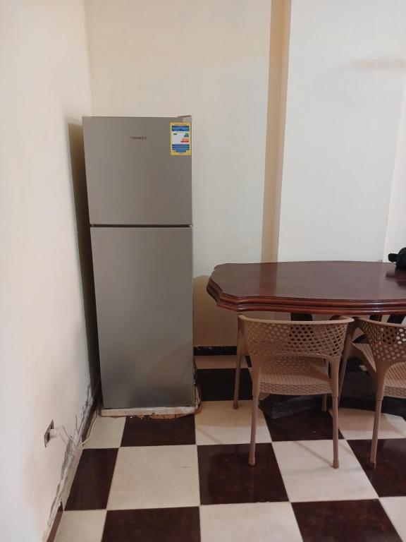 a refrigerator sitting next to a table in a room at furnished apartment 10th of ramadan- شقة مفروشة in Madinat Al Ashir min Ramadan