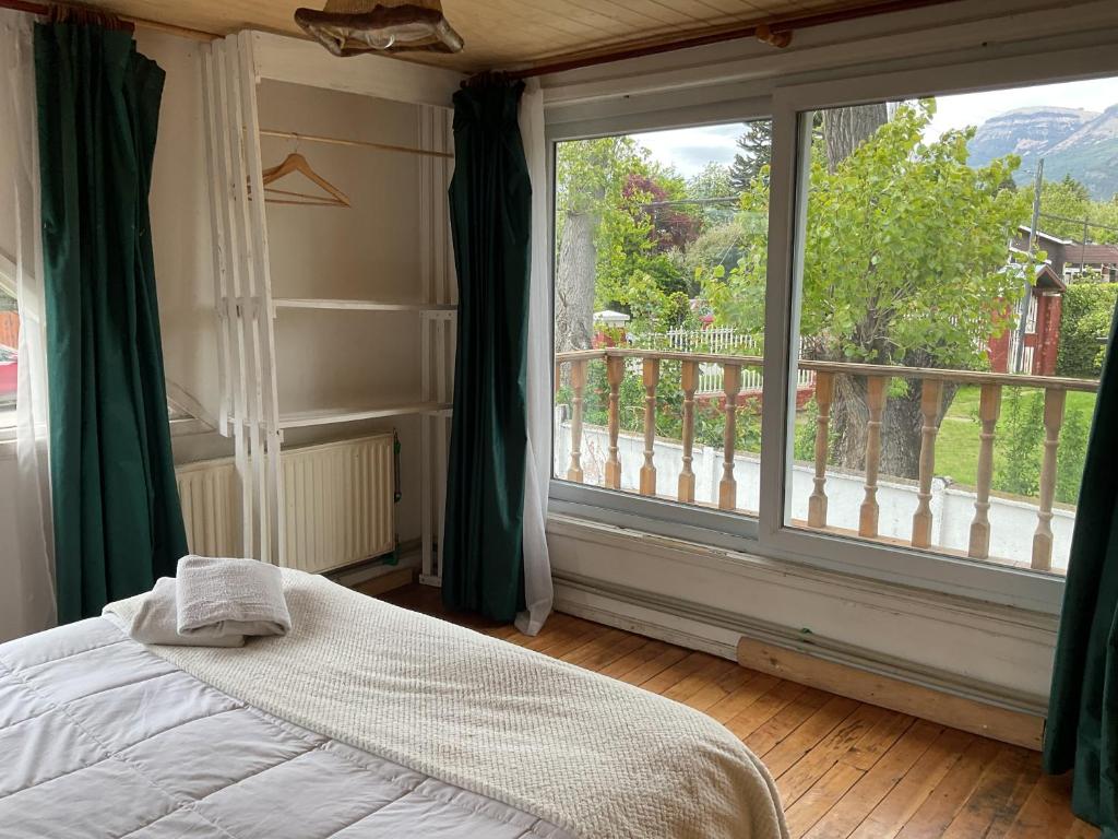 1 dormitorio con cama y ventana grande en Casa Balmaceda Backpackers, en Coyhaique
