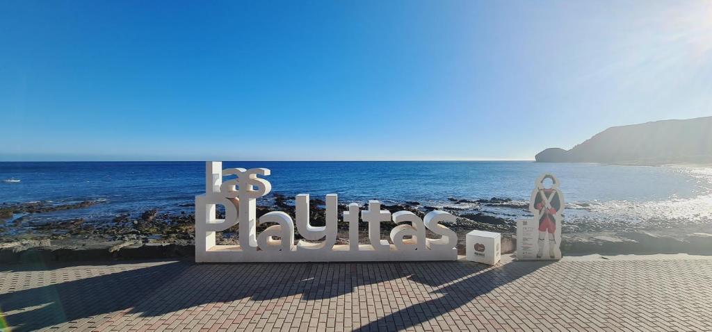un panneau indiquant ses planètes sur la plage dans l'établissement Apartamento Playitas Salema, à Las Playitas