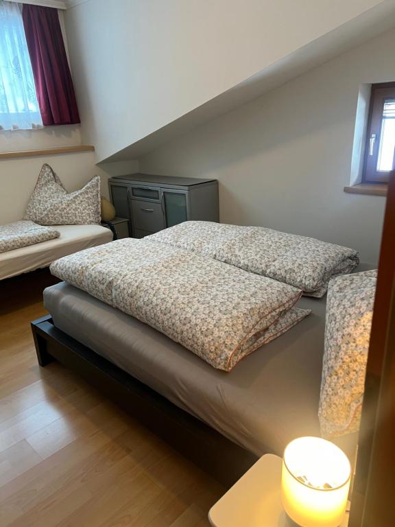 een slaapkamer met een bed en een bank bij Ortners Ferienwohung in Bischofshofen