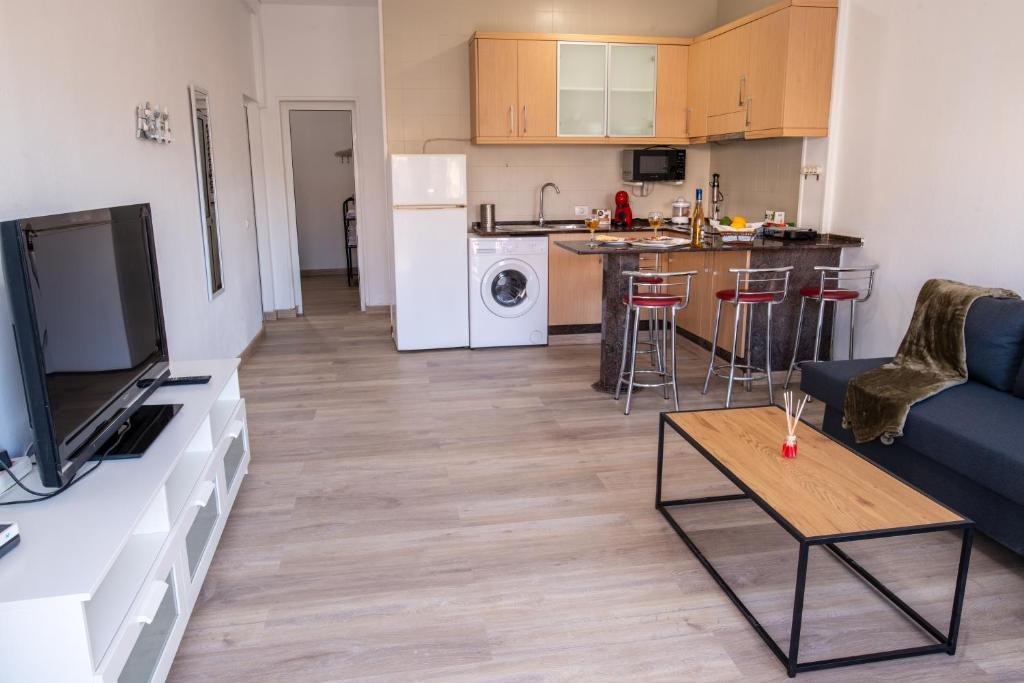 a living room with a blue couch and a kitchen at Casa Andrea Doria Arinaga B in Arinaga