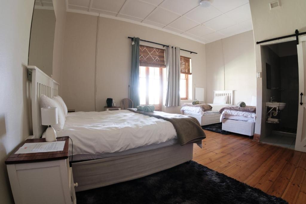 a bedroom with a large white bed and a window at The Border Post, Bed and Breakfast in Bergville