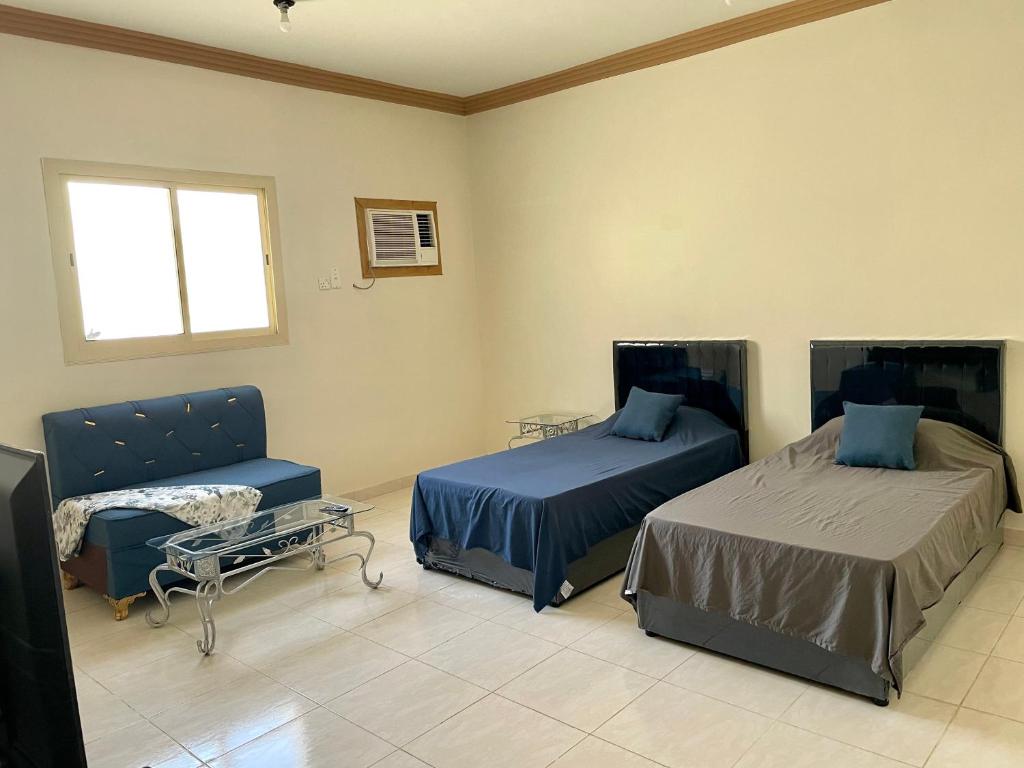 Al-Salam的住宿－ستوديو كبير غرفة و حمام بمكيف غسالة تلفاز واي فاي，客房设有两张床、椅子和桌子。