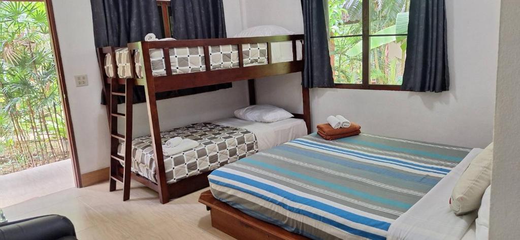 a bedroom with two bunk beds and a bed at Khao Sok Holiday Resort in Khao Sok National Park