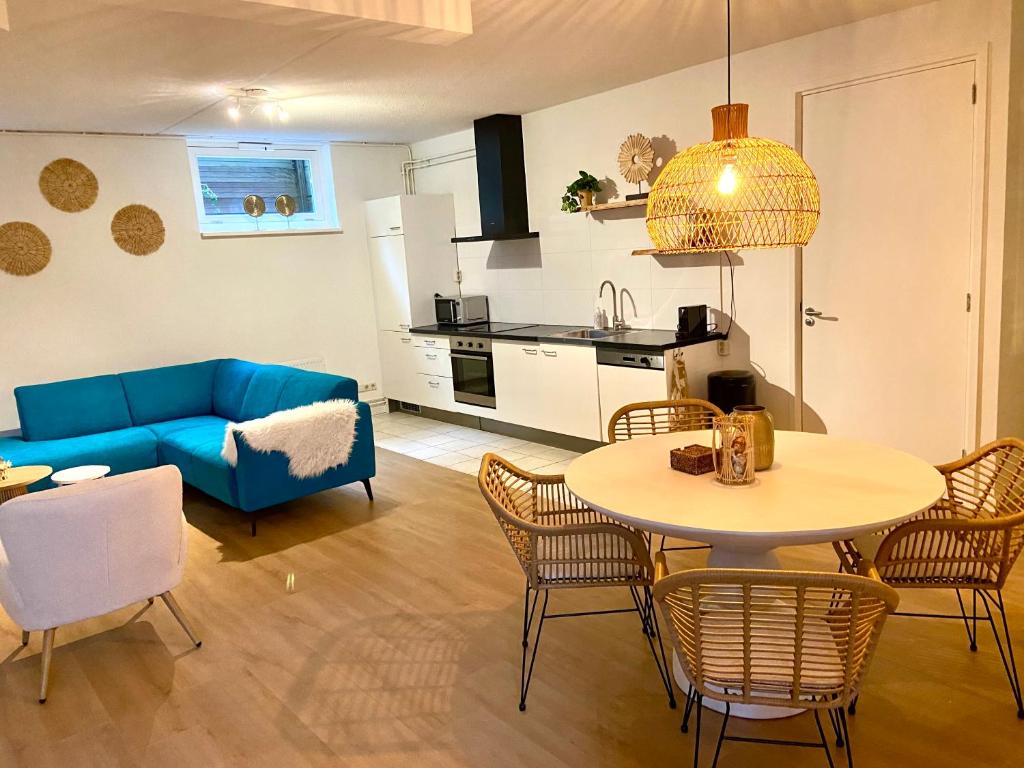 a living room with a blue couch and a table at Appartement Bloem in Zandvoort