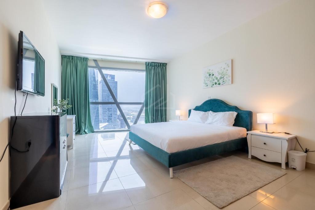 1 dormitorio con cama y ventana grande en Difc 1 Bd apartment in Park Tower en Dubái