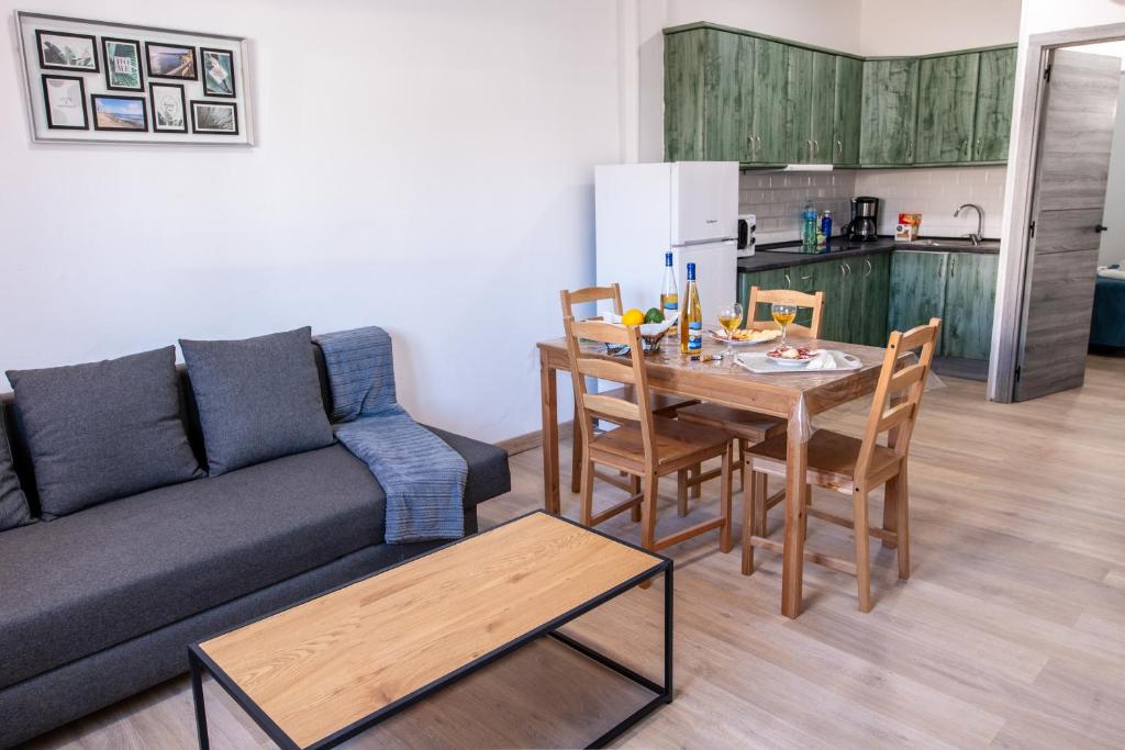 een woonkamer met een bank en een tafel met stoelen bij Casa Andrea Doria Arinaga in Arinaga