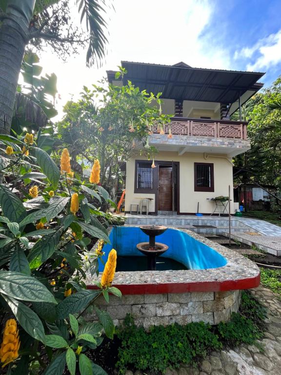 a house with a fountain in front of a yard at The Quiet Villa in Tagaytay