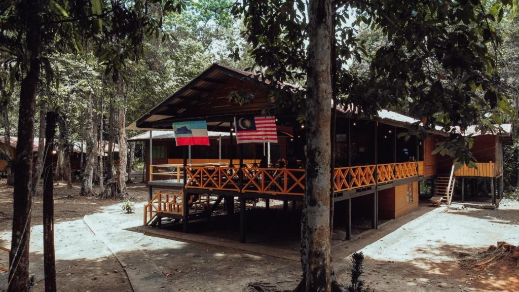 un edificio en el bosque con una bandera americana en Borneo Jungle Adventure en Kinabatangan