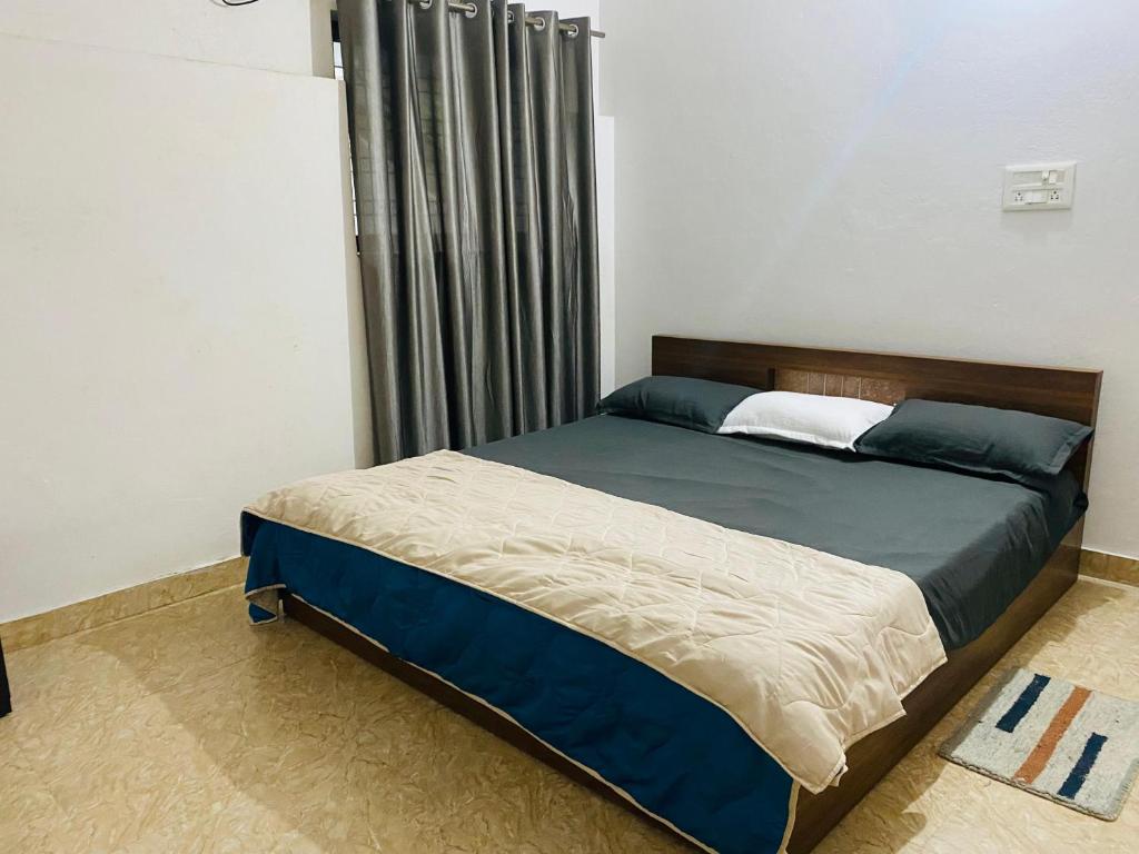 um quarto com uma cama grande e lençóis azuis em Independent 2-Room with Kitchen Homestay em Dehradun