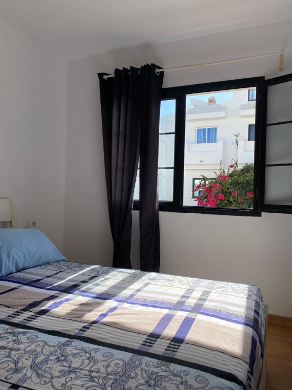 a bedroom with a bed and a window at La Fresa Hostel in Corralejo