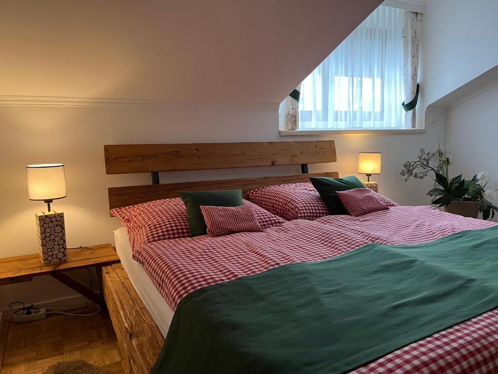 1 dormitorio con 1 cama grande con sábanas rojas y verdes en Alpin Chic en Grödig