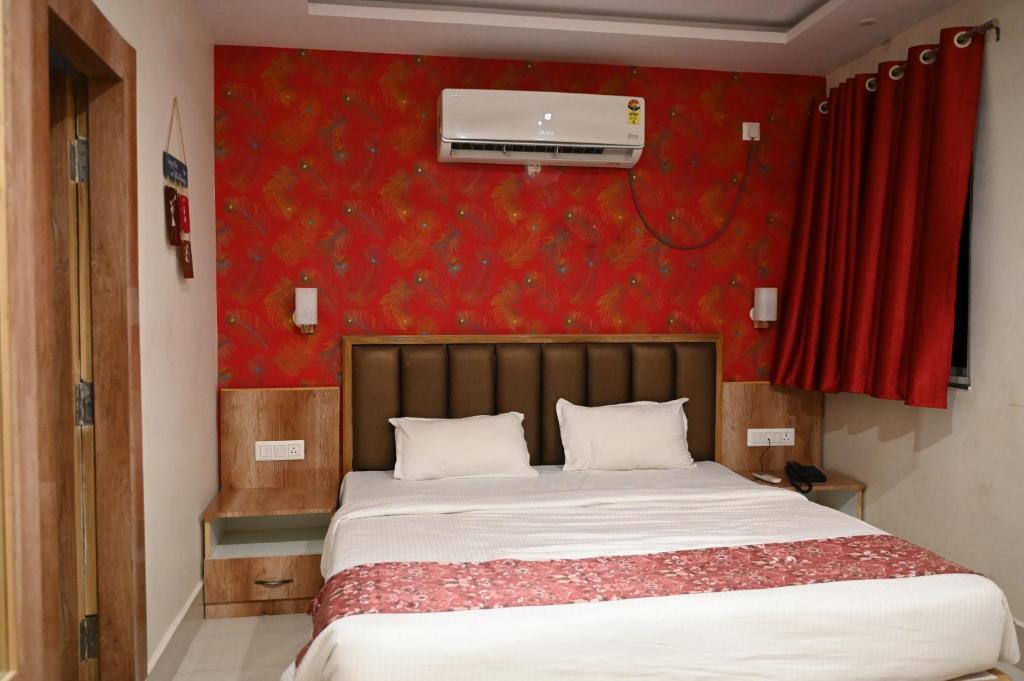 THE M K HOTEL -Luxury In Style في Chās: غرفة نوم بسرير بجدار احمر