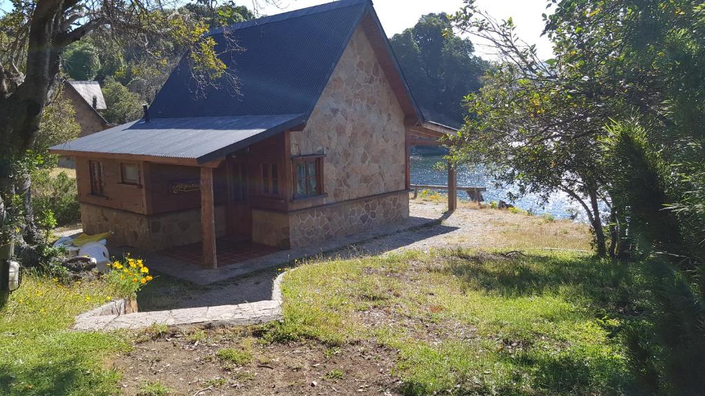 a small house with a blue roof in a yard at CABAÑAS SOLO POR HOY in Villa Pehuenia