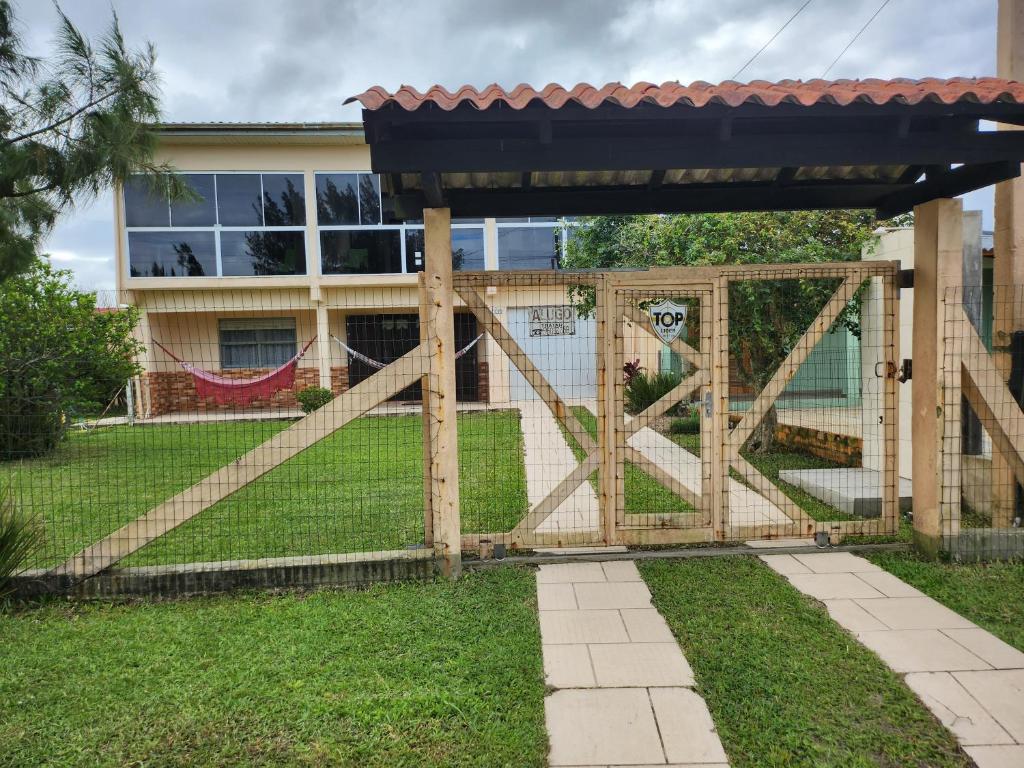 een houten hek voor een huis bij Casa Andar Térreo - Balneário Nordeste - Imbé - RS in Imbé