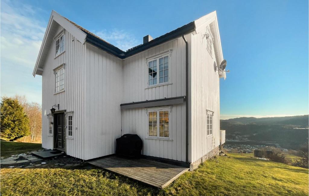 a white house on top of a grassy hill at Pet Friendly Home In Svorkmo With House A Panoramic View 