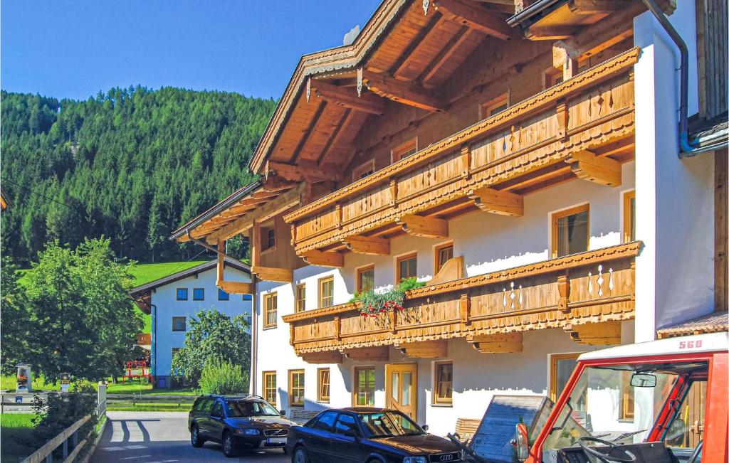 a building with wooden balconies and cars parked on the street at Nice Apartment In Hainzenberg With House A Mountain View in Zell am Ziller