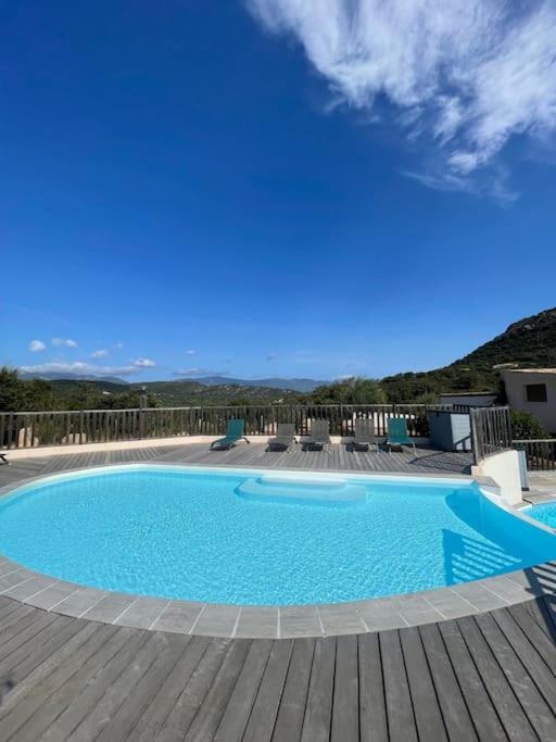 une piscine sur une terrasse en bois avec un ciel bleu dans l'établissement Appartement & Piscine Santa Giulia, à Porto-Vecchio