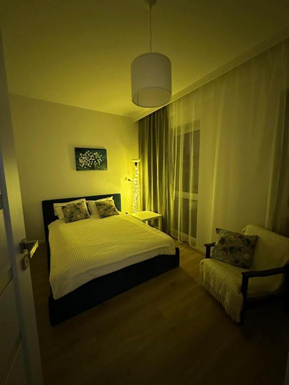 a bedroom with a bed and a chair in it at Apartament ANNA in Biała Podlaska