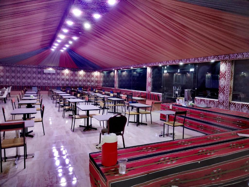 a dining room with tables and chairs and red curtains at rum guest house in Wadi Rum