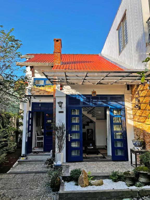 a house with blue doors and an orange roof at Thiên Trúc Ecohome, đồi Từ Hiếu in Thôn Dương Xuân Hạ