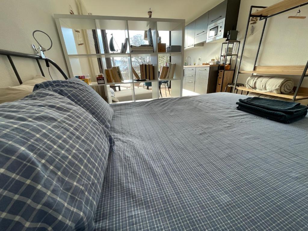 a bedroom with a bed with a blue plaid at Escapade Ticino in Neggio