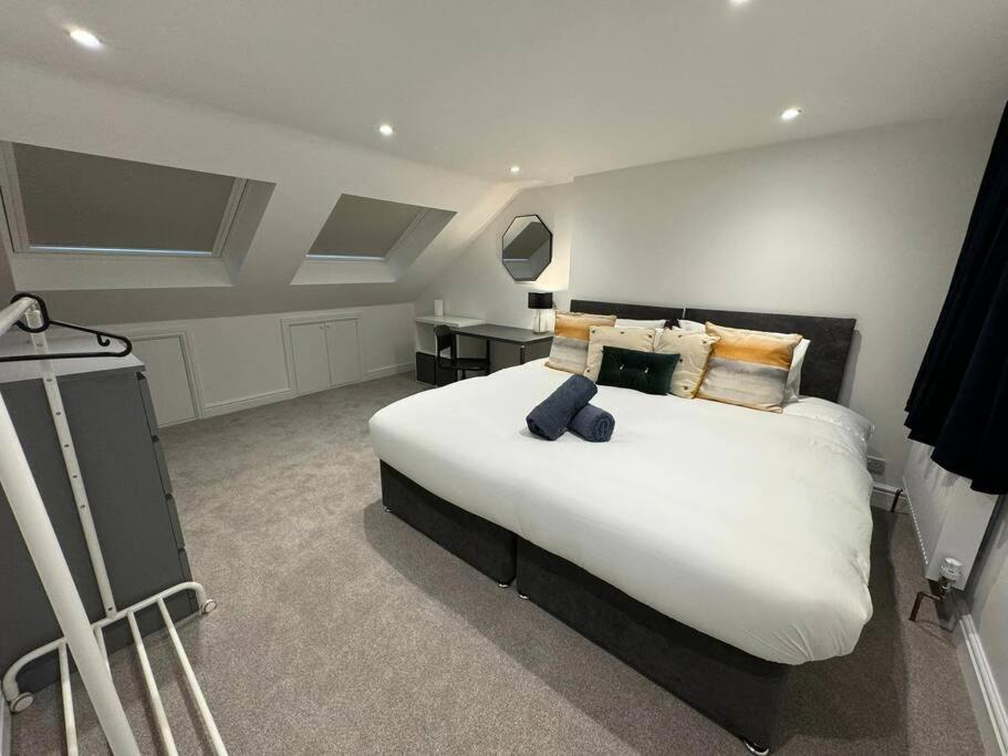 um quarto com uma grande cama branca e uma secretária em Modern 5 Bed near ExCel -Big Ben em Londres