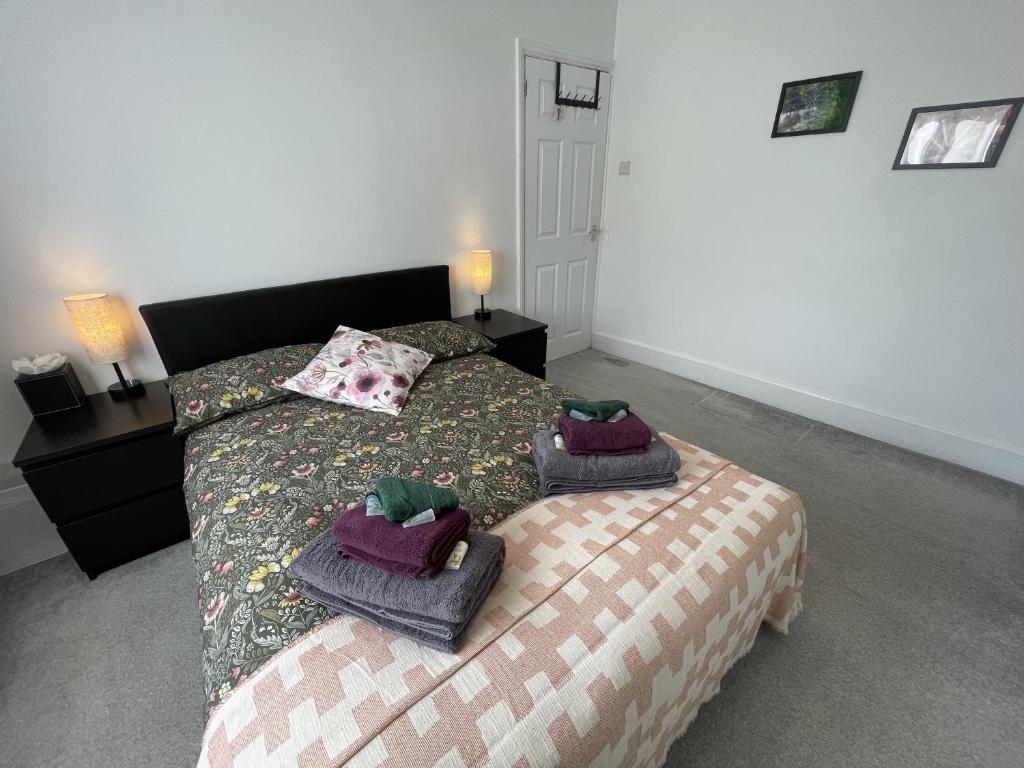 a bedroom with a bed with towels on it at Double Bedroom in Sudbury Hill Wembley - 10 mins from Wembley Stadium in Harrow on the Hill