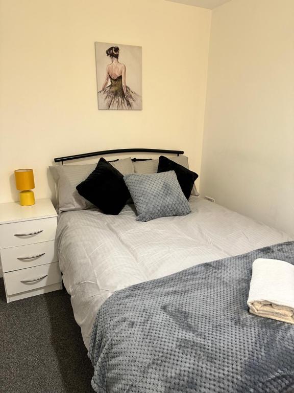 a bedroom with a bed and a dresser and a picture at Lovely Town house Room 4 in Parkside