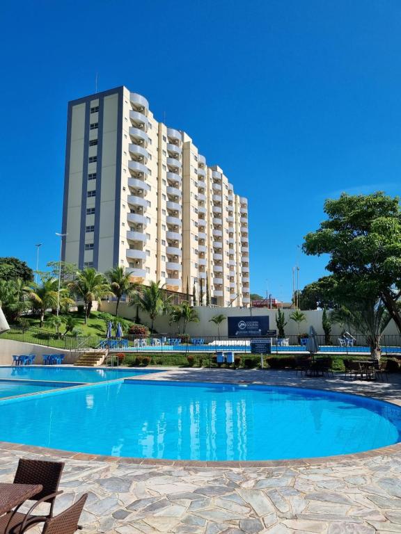 a large swimming pool in front of a tall building at Flat 317 Golden Dolphin Express in Caldas Novas