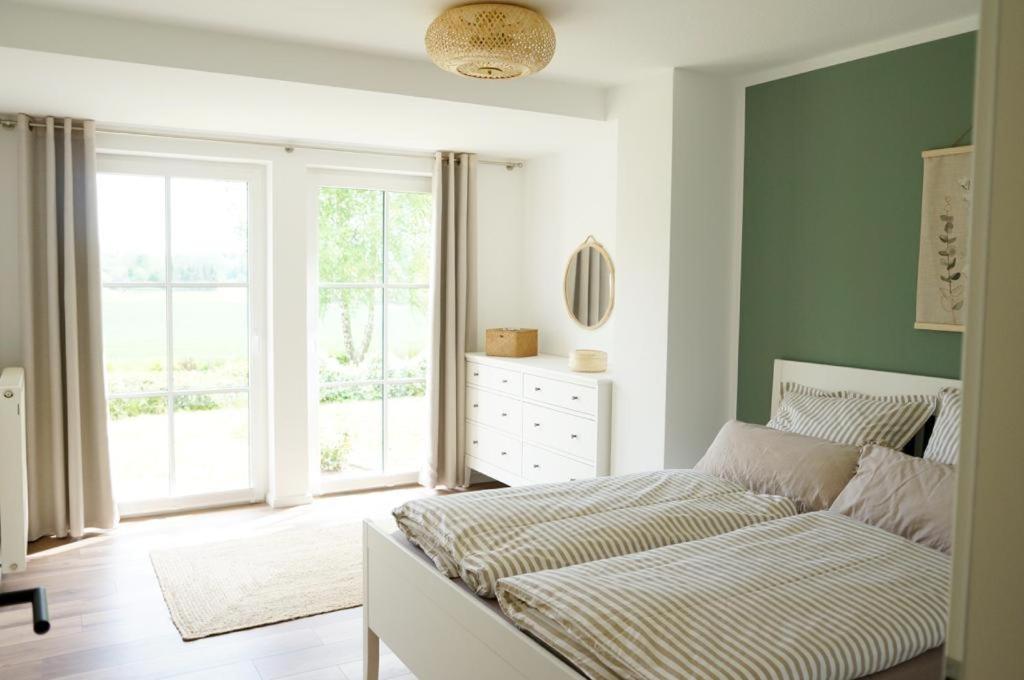 a bedroom with a bed and a large window at Ferienwohnung Feldblick in Sehlen