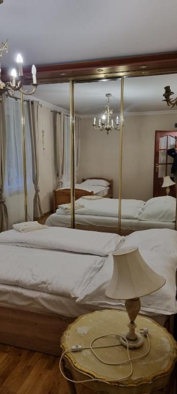um quarto com 2 camas e uma mesa com um candeeiro em Apartament Łomnicki em Karpacz