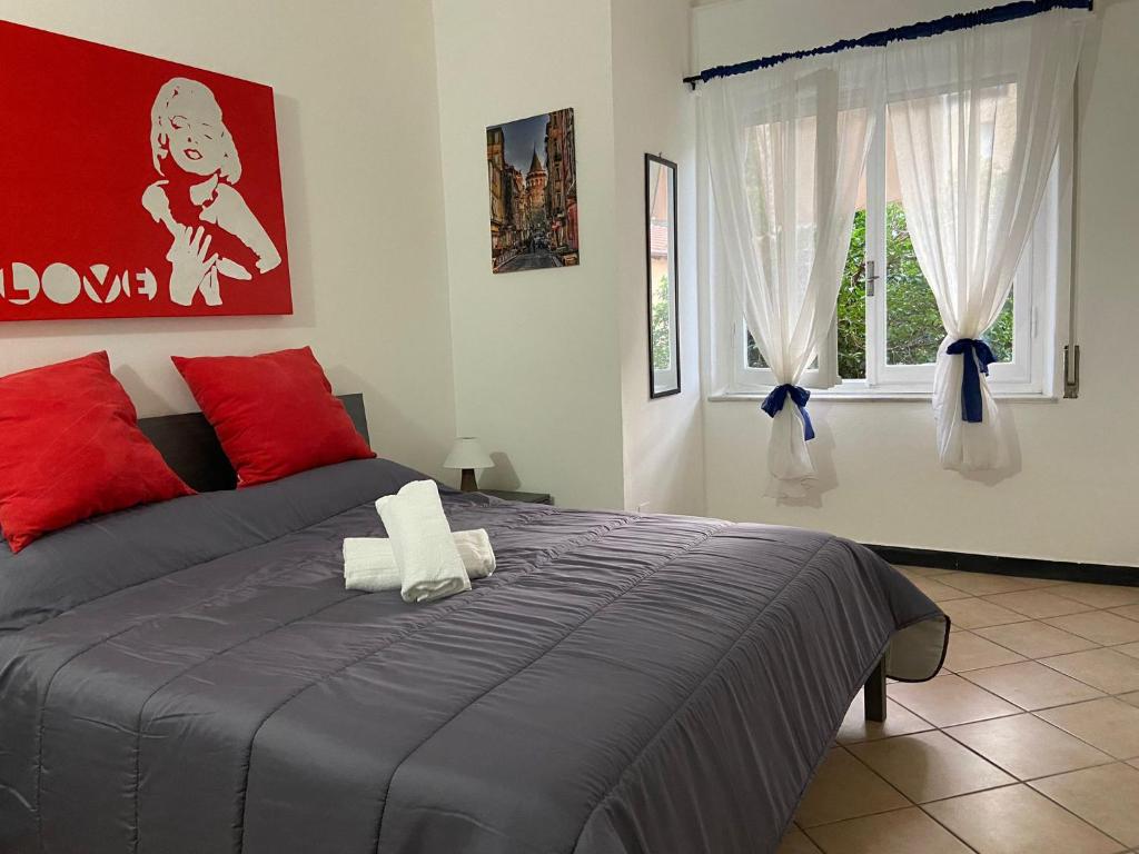 a bedroom with a bed with red and white pillows at Right Bank House in Imperia