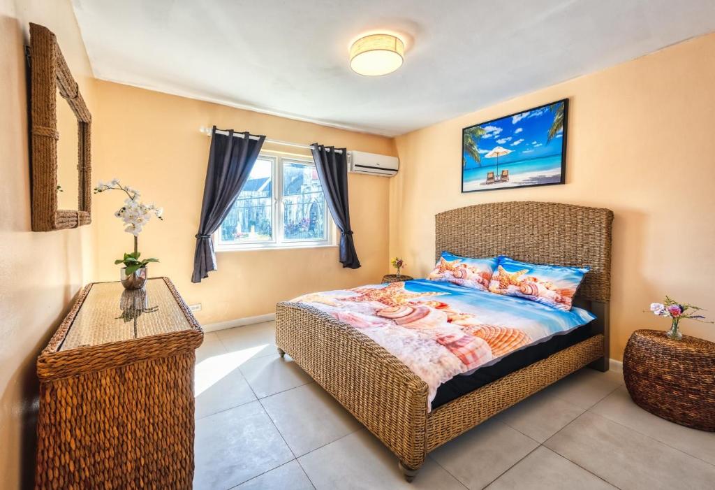 a bedroom with a bed and a table and a window at Apartment in downtown at the beach in Nassau