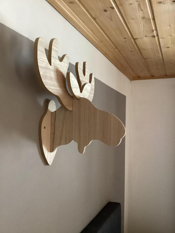 a wooden deer sign on the wall of a room at Apartement für Naturliebhaber in Fischbachau