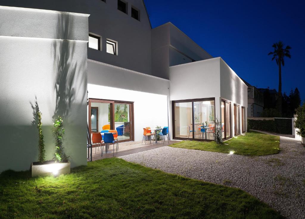 a large white house with a patio and lawn at Hotel Villa Sveva in Cagliari