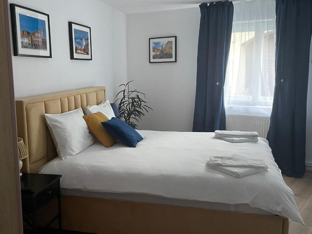 a bedroom with a bed with blue and yellow pillows at Sweet-Bombon Sibiu in Sibiu