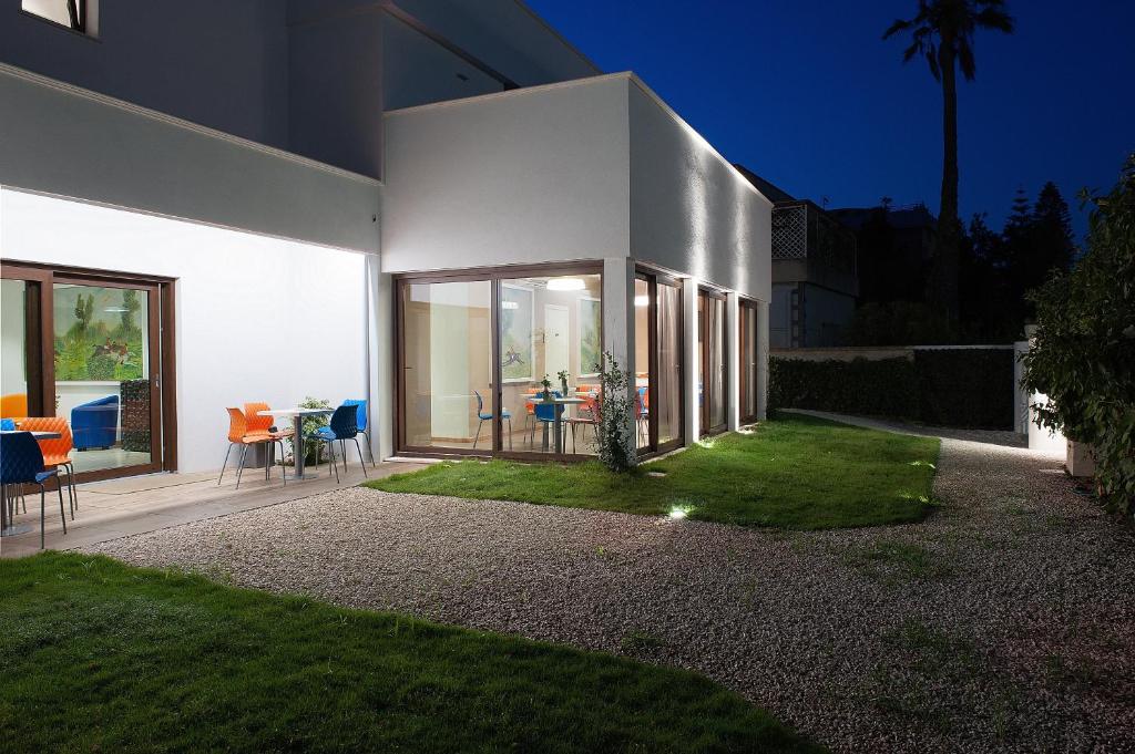 a large white house with chairs and a table at Hotel Villa Sveva in Cagliari