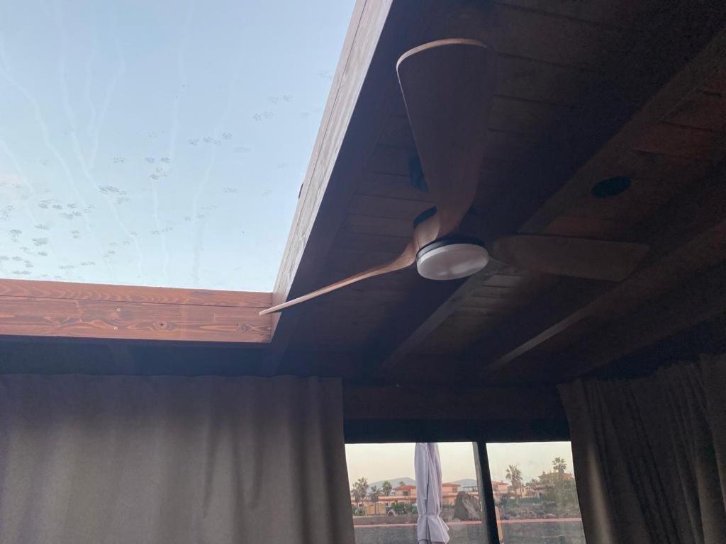 a ceiling fan on a room with a window at Exclusive Stars view Experience in La Oliva