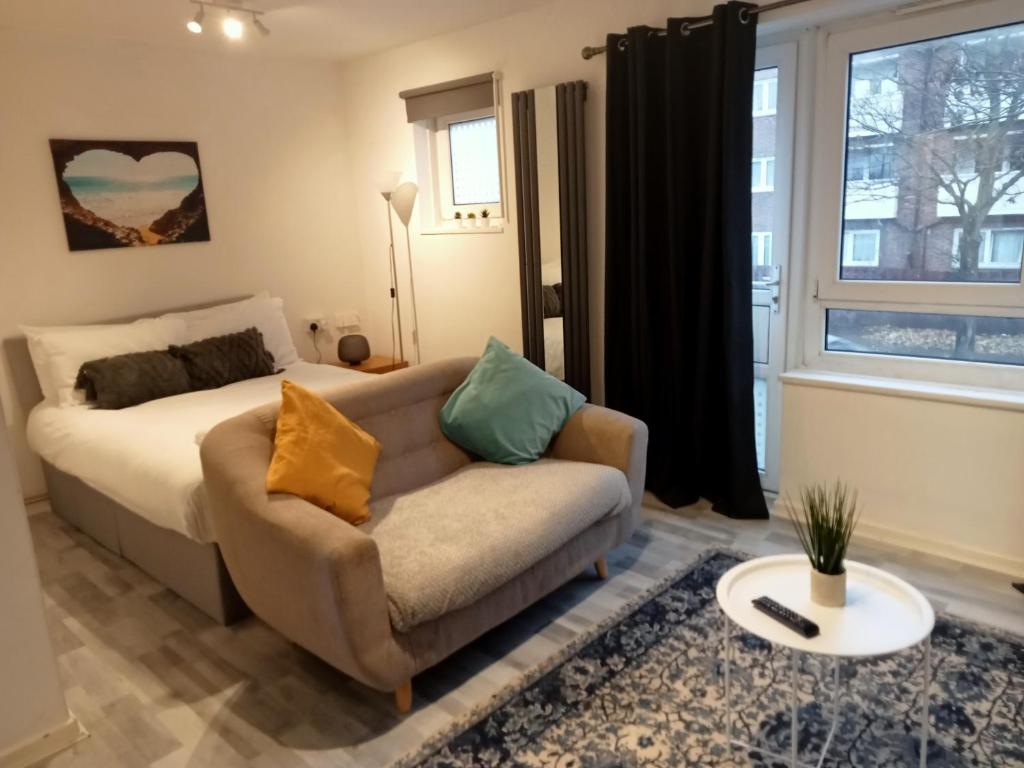 a living room with a couch and a bed at Studio apartment in London, Bethnal Green in London